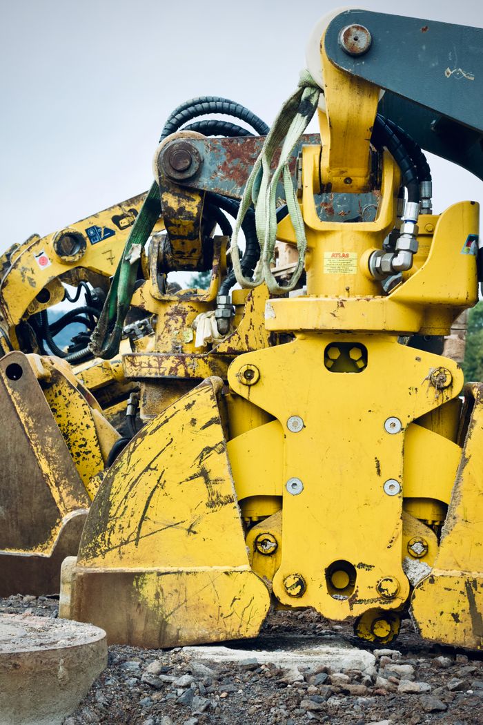 Detailed view of heavy-duty construction equipment with rust and dirt, showcasing industrial strength.